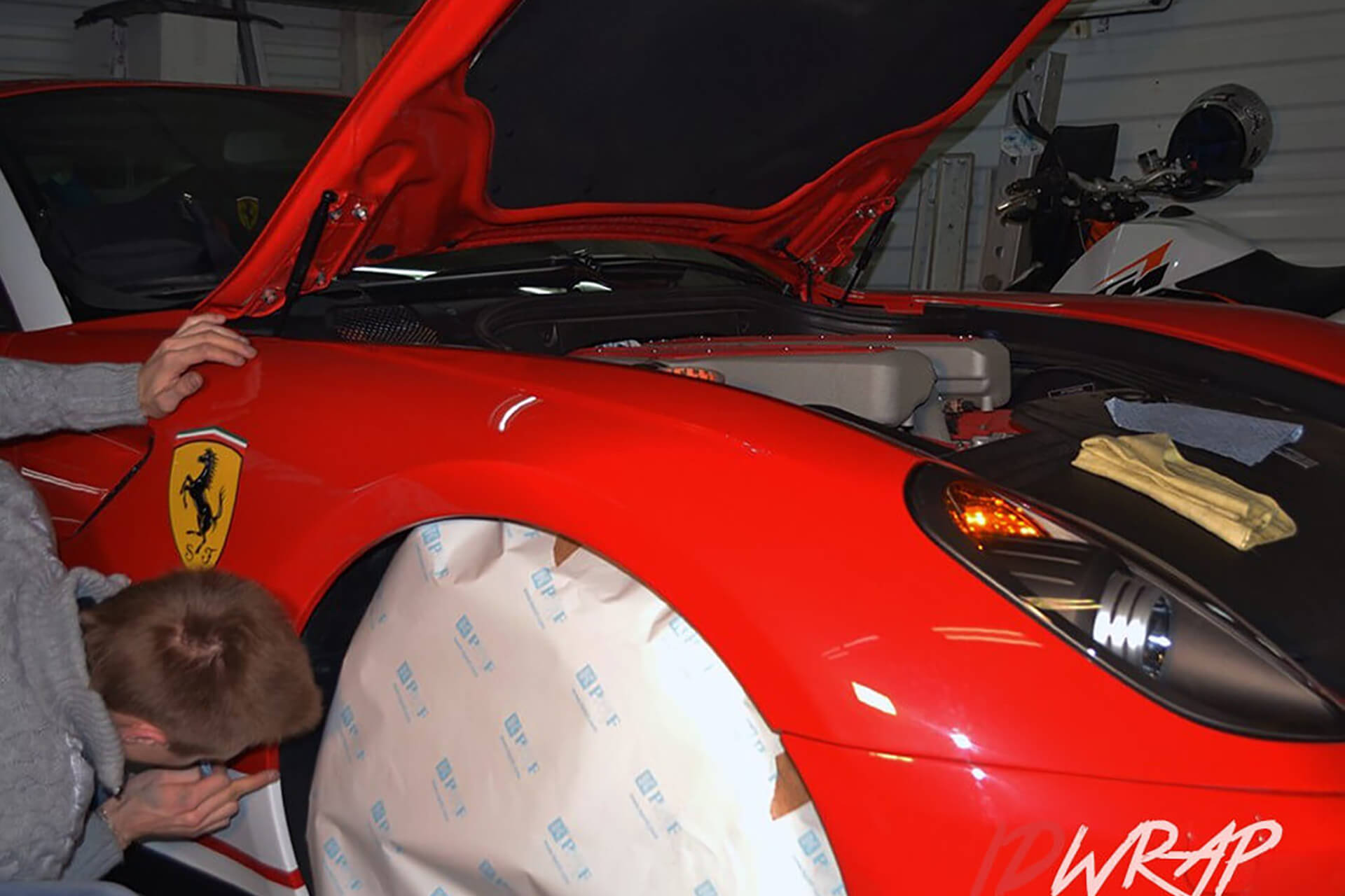 Красный Ferrari в глянцевой пленке