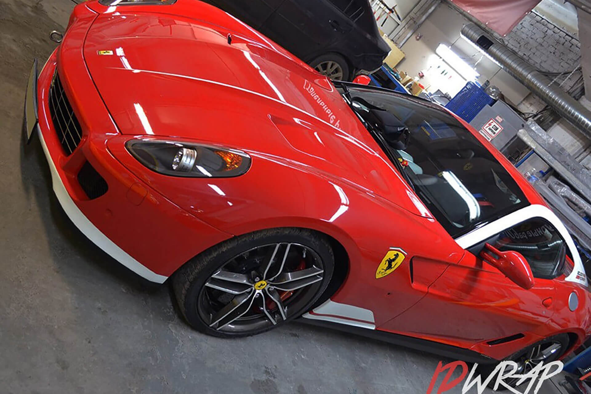 Красный Ferrari в глянцевой пленке