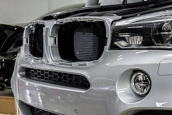  На фото BMW x5 - броня передней части авто и фар 